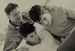 Photo of three people looking at computer